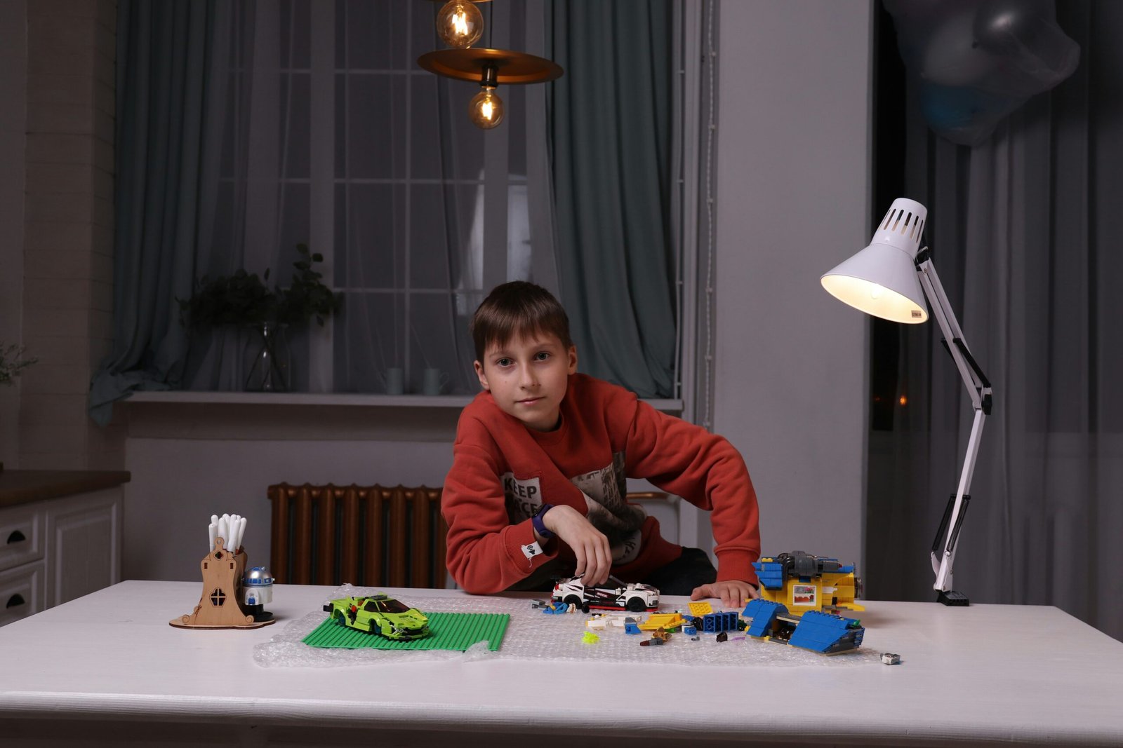 a young boy playing with a lego set on a table